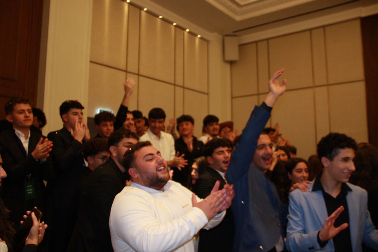 Delegates cheering and applauding together in a ballroom
